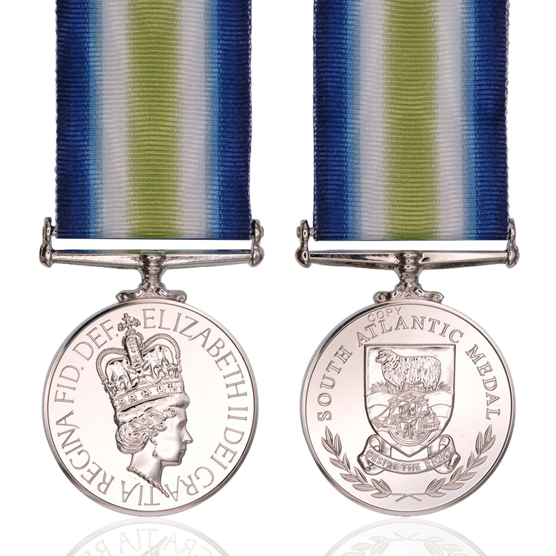 Front and back views of a South Atlantic Medal with a blue, white, and green striped ribbon, displayed on a clean white background with a subtle reflection.