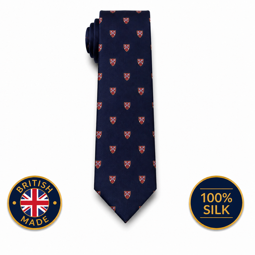 A navy blue silk necktie with a repeating pattern of small red and gold shield emblems, shown on a white background with two circular badges indicating 'British Made' and '100% Silk'.